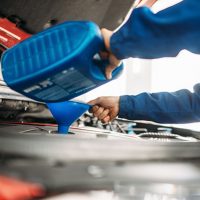 Image showing a technician performing a vehicle safety inspection and changing oil in a vehicle