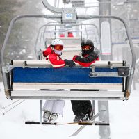 image of skiiers on a ski lift, one of the top winter activities in Utah