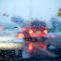 Image of cars driving in the rain at night