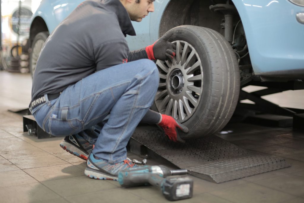man performing maintenance on an electric vehicle